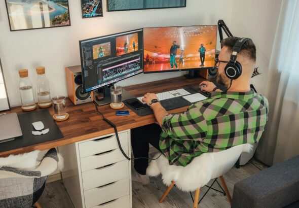 a person sitting at a desk with a computer and a dog